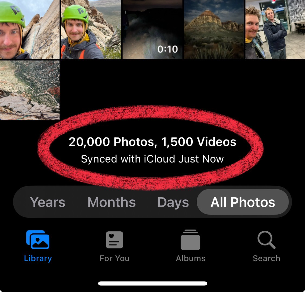 A screenshot of a photo gallery app showing thumbnail previews and a notification that reads &ldquo;20,000 Photos, 1,500 Videos Synced with iCloud Just Now.&quot;
