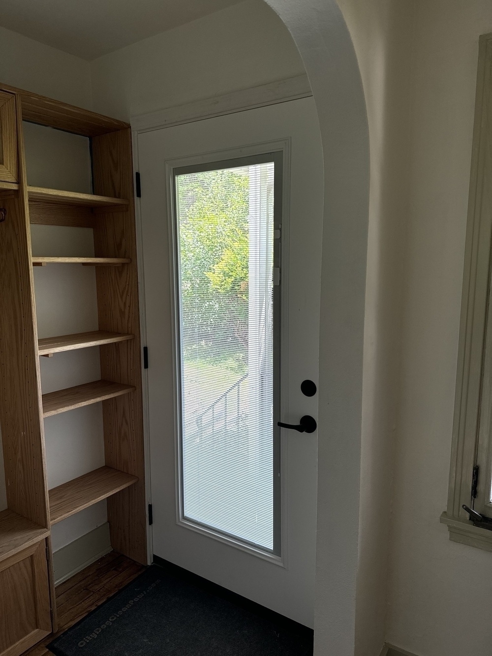 A new exterior door, from inside of a house, with a large window.