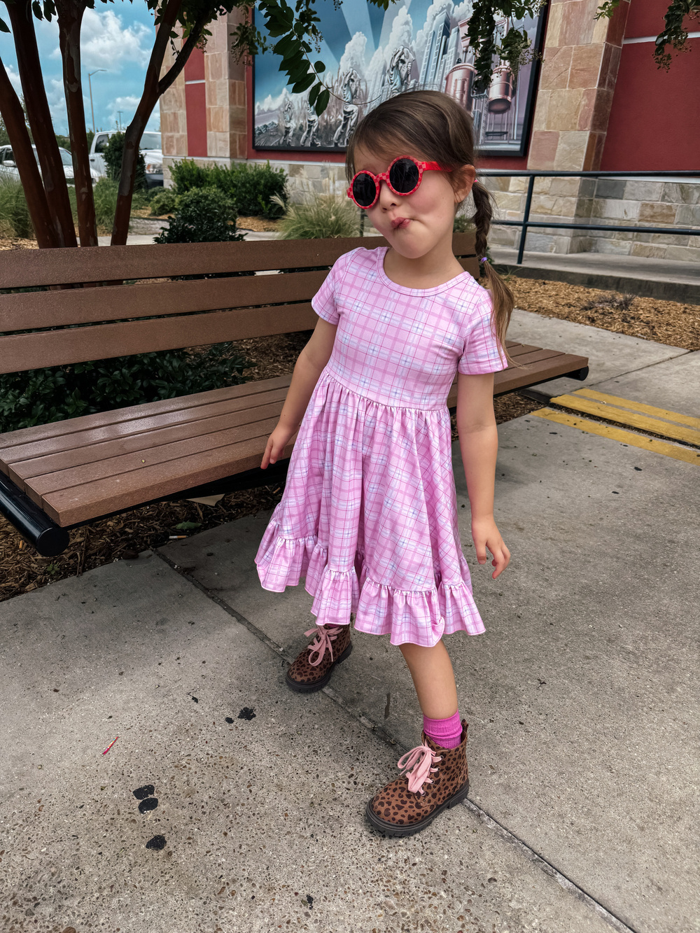 A girl in a pink dress and sunglasses
