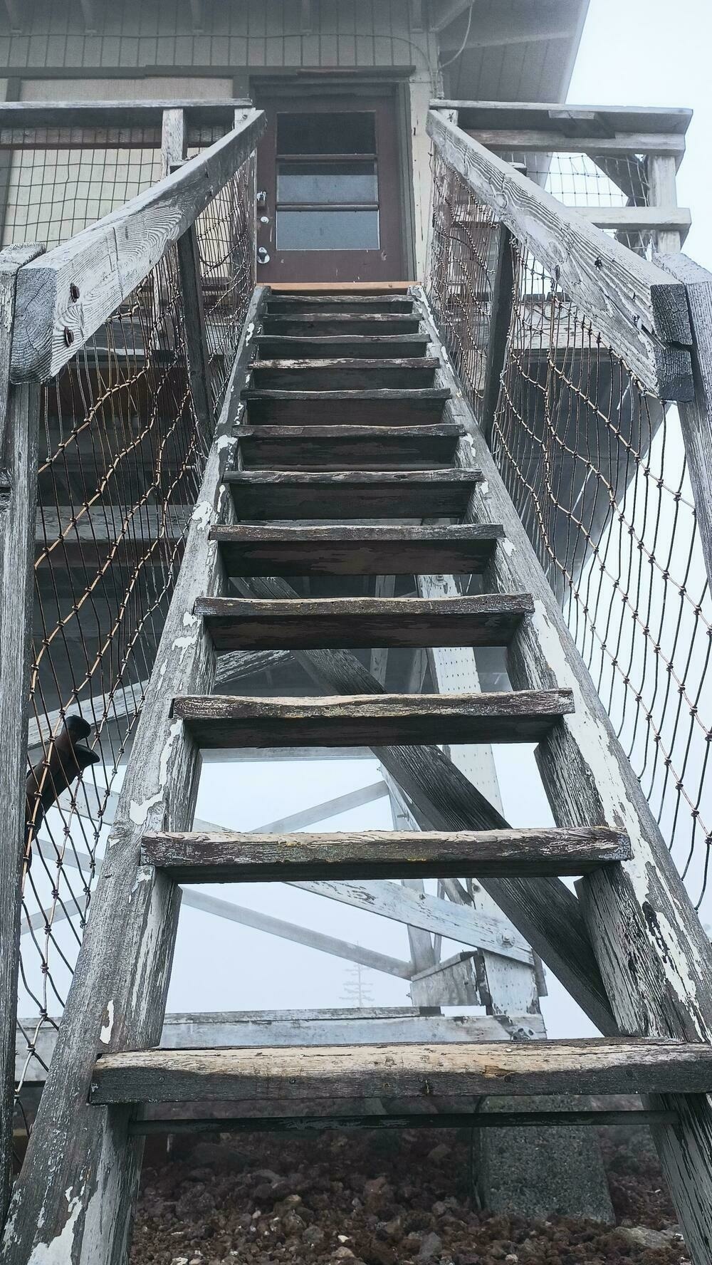 Looking up the steep wooden stairs to the lookout. The view behind the lookout is completely obscured by fog.