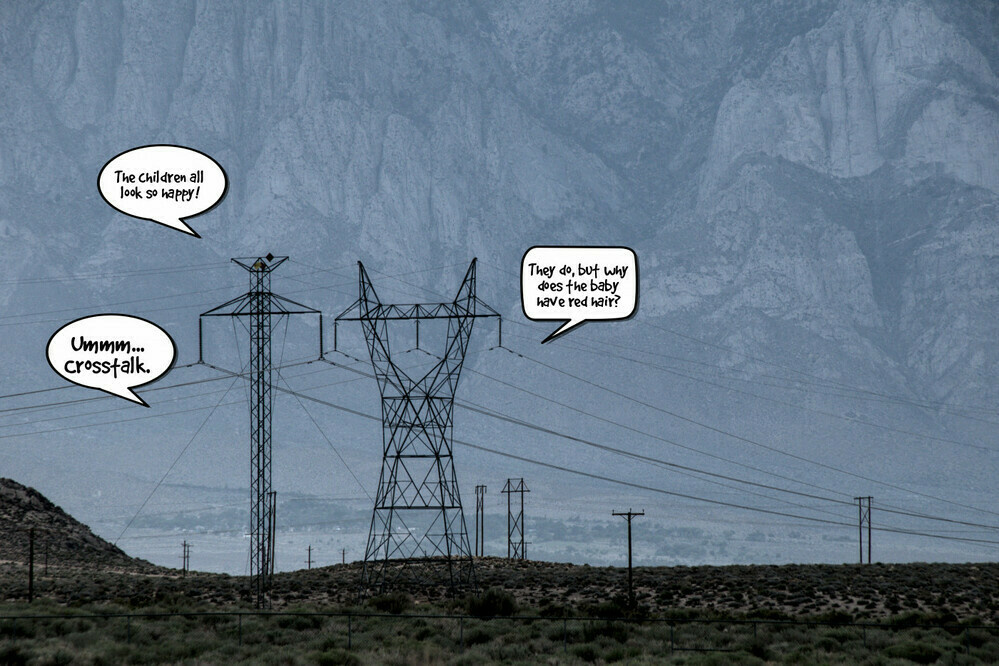 Two power transmission towers stand next to each other, but they are shaped very differently. They are having a conversation about the smaller towers, as if they were married and the children before them.
