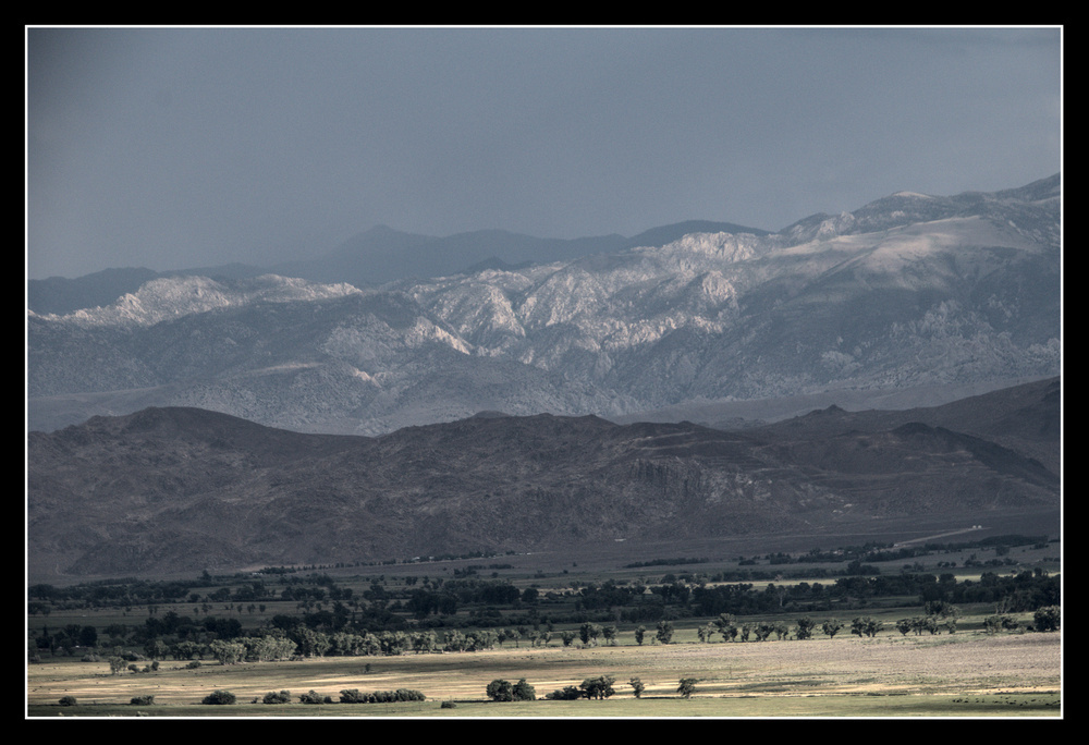 Green valley gives way to rocky hills, then granite mountains, an finally grey sky.