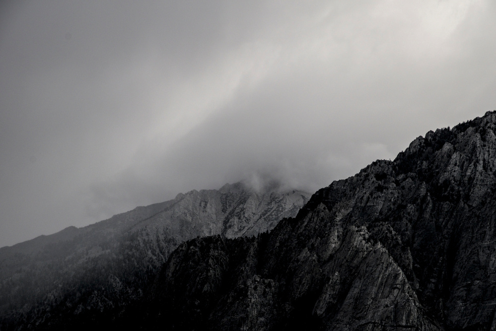 Rain falls on a mountain ridge and valley, obscuring most details.