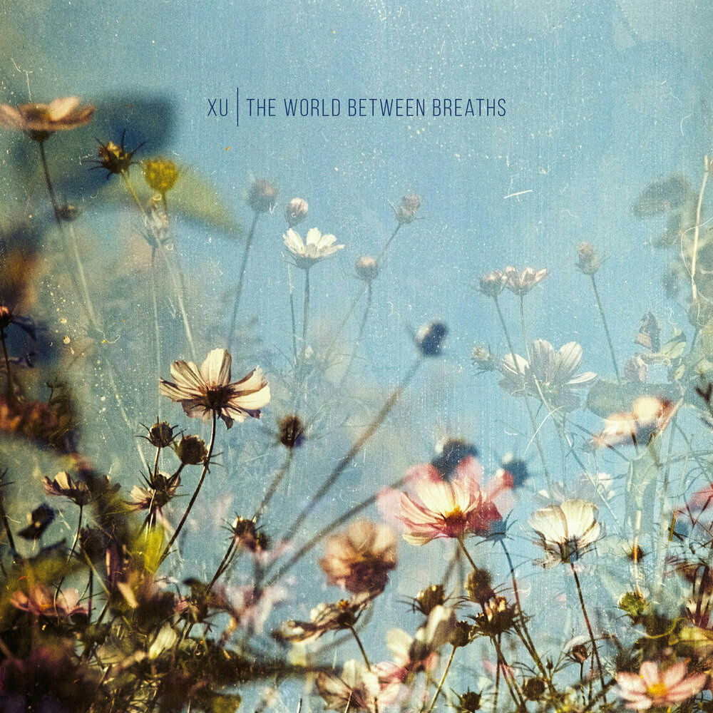 XU. The World In Between Breaths cover artwork. Light blue with layers of flower photography on it, different opacity and partially blurred but all in warm colours.