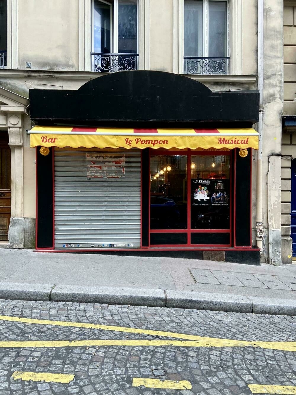 The front of a bar called Le Pompon with the signs written in the Lobster typeface 