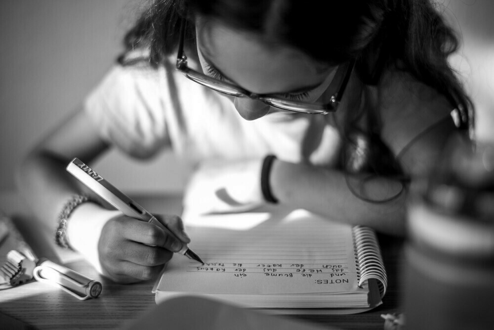 Monochrome image of my daughter practicing writing with her fountain pen