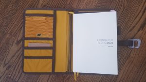 A Hobonichi Techo 2022 planner in a brown Lochby notebook cover with a yellow interior