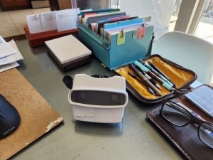 White View-Master on desk next to a card index file and a variety of mechanical pencils and pens