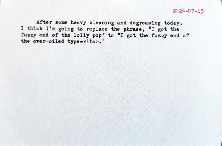 Typed index card that reads: After some heavy cleaning and degreasing today, I think I'm going to replace the phrase, "I got the fuzzy end of the lolly pop" to "I got the fuzzy end of the over-oiled typewriter."