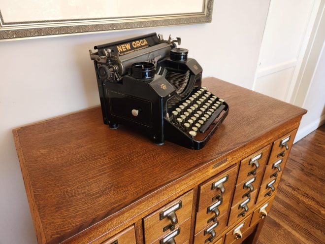 Angled view on a black vintage typewriter on a wooden library card catalog