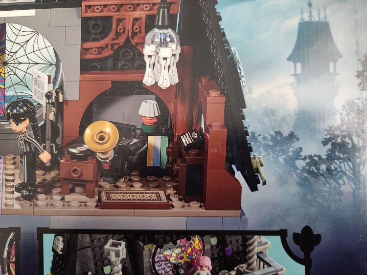 Close up of a LEGO version of Wednesday Addams dorm room at Nevermore featuring a tiny black LEGO brick typewriter