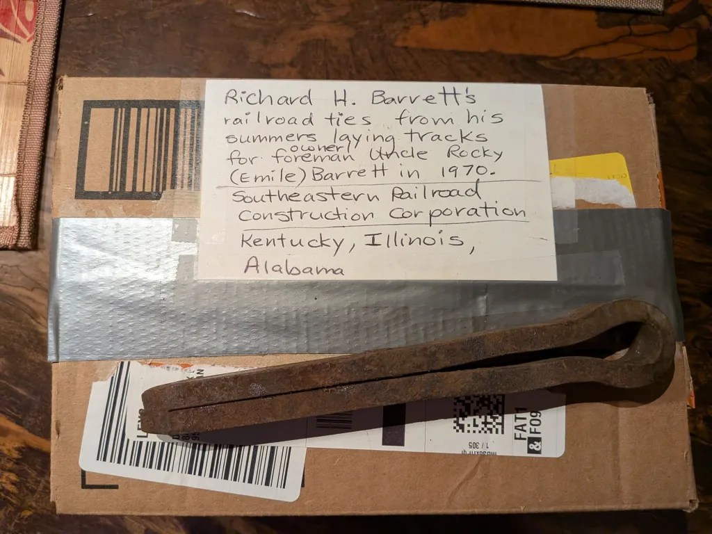 Box with railroad cotter pin on top. Label says:

Richard H. Barrett's railroad ties from his summers laying tracks for foreman Uncle Rocky (Emile) Barret in 1970.

Southeastern Railroad Construction Corporation

Kentucky, Illinois, Alabama