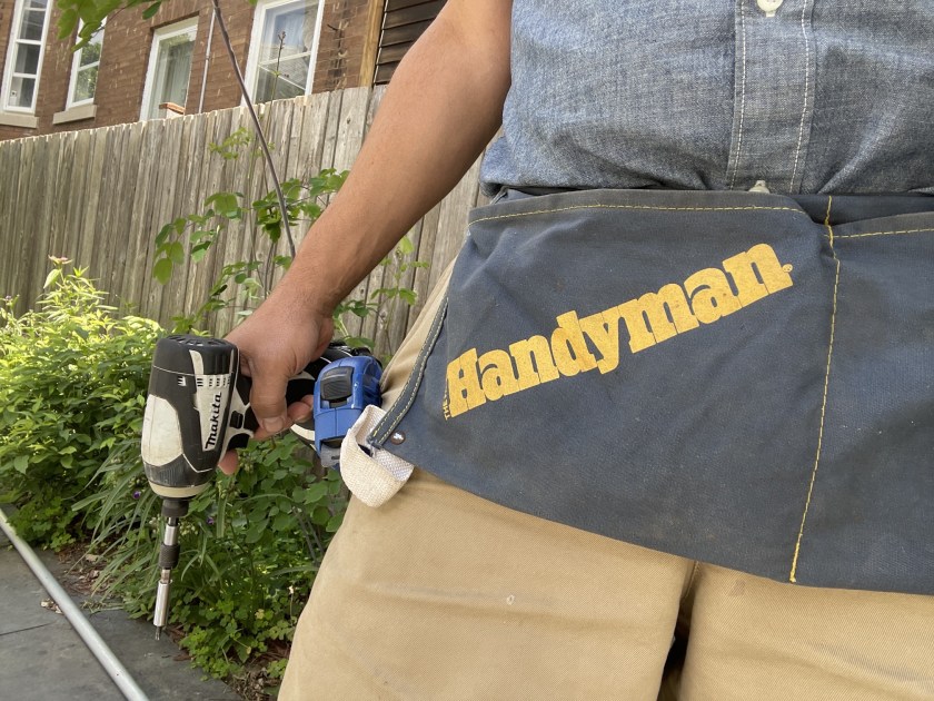 Me holding a drill and wearing a carpenter's apron printed with the Family Handyman magazine logo.