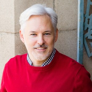 Headshot of Chris Aldrich in a red sweater.