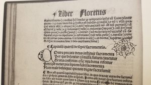 Illuminated printed leaf from the Floretus cum commento featuring a flower drawn into the open space of a twelfth-century florilegium attributed to Bernard de Clairvaux.