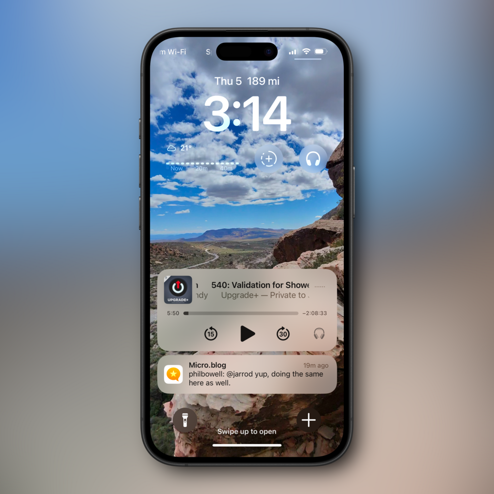 Smartphone displays a lock screen with 3:14 time. Background shows a desert landscape with a cloudy sky. Notifications include weather (21°, sunny), a podcast playing, and a Micro.blog message.