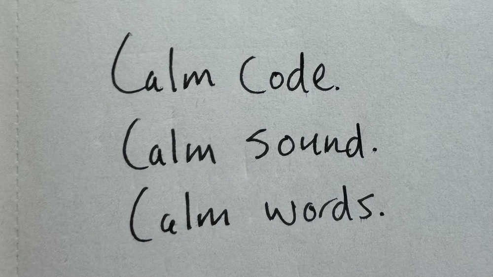 A handwritten message on a paper reads, "Calm Code. Calm sound. Calm words."