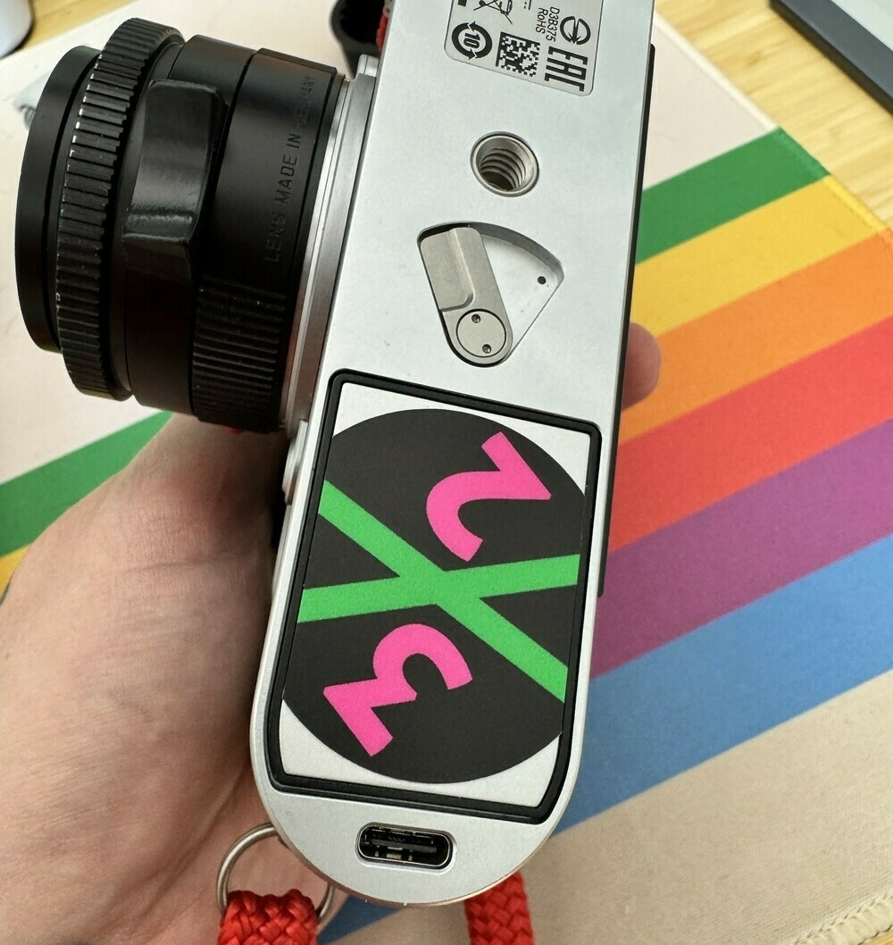 Camera battery with a 3x2 photo cast logo on it inserted into camera. 