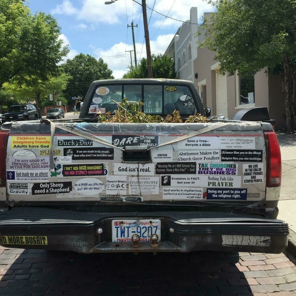Truck tailgate covered in left wing, irreligious number stickers