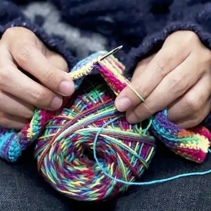 hands knitting colorful yarn