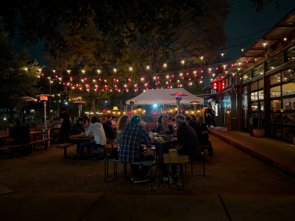 Cafe with outdoor seating at night with string lights