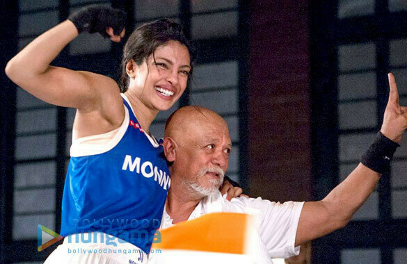 Still from the movie showing MaryKom and her coach with arms in the air celebrating a success. 