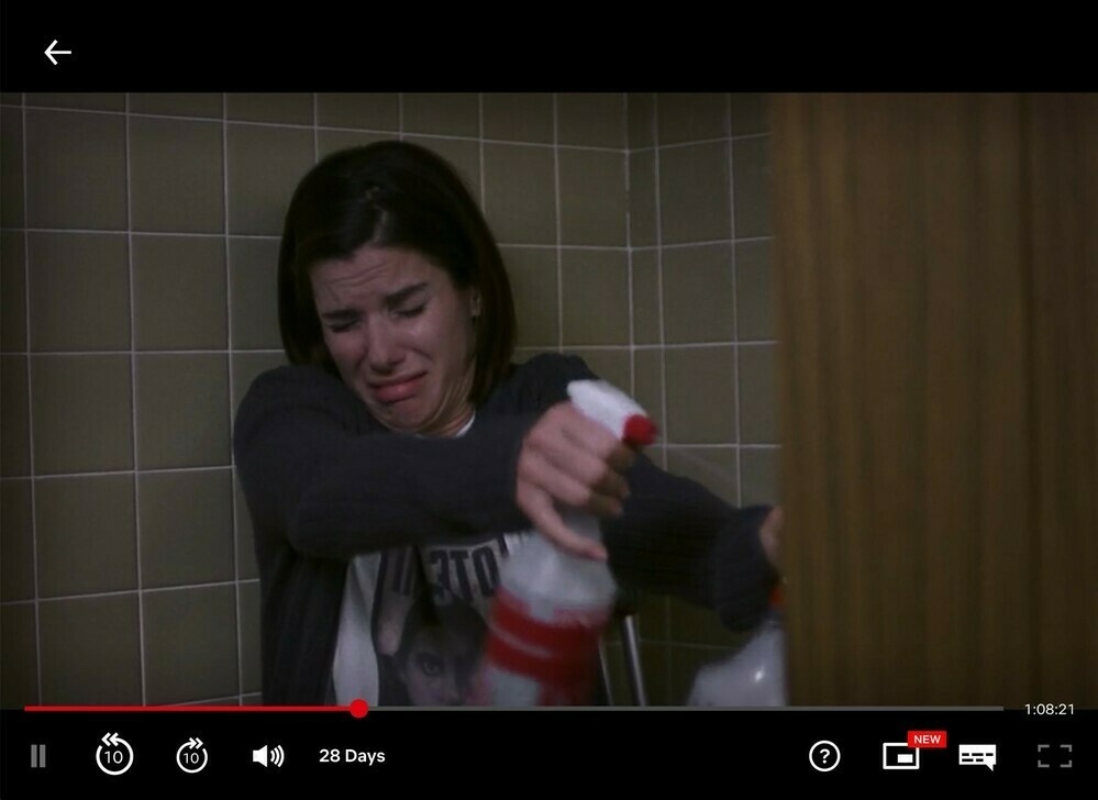 Still from 28 Days showing lead actor Sandra Bullock spraying cleaner from a bottle.