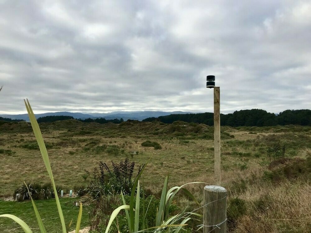 Wind gauge attached to a post more than a metre higher than the previous post. background: farm landscape.
