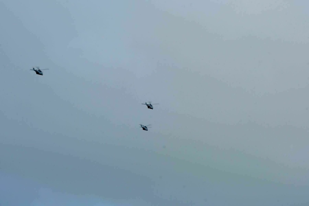 3 military helicopters in formation, flying away. 