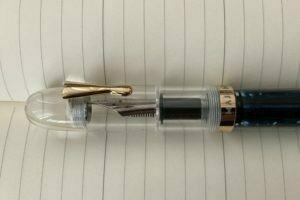 view of the top half of a clear acrylic Majohn C4 eyedropper pen, showing off the short clip on the cap