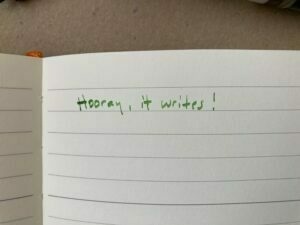 "Hooray, it writes!" written in green ink