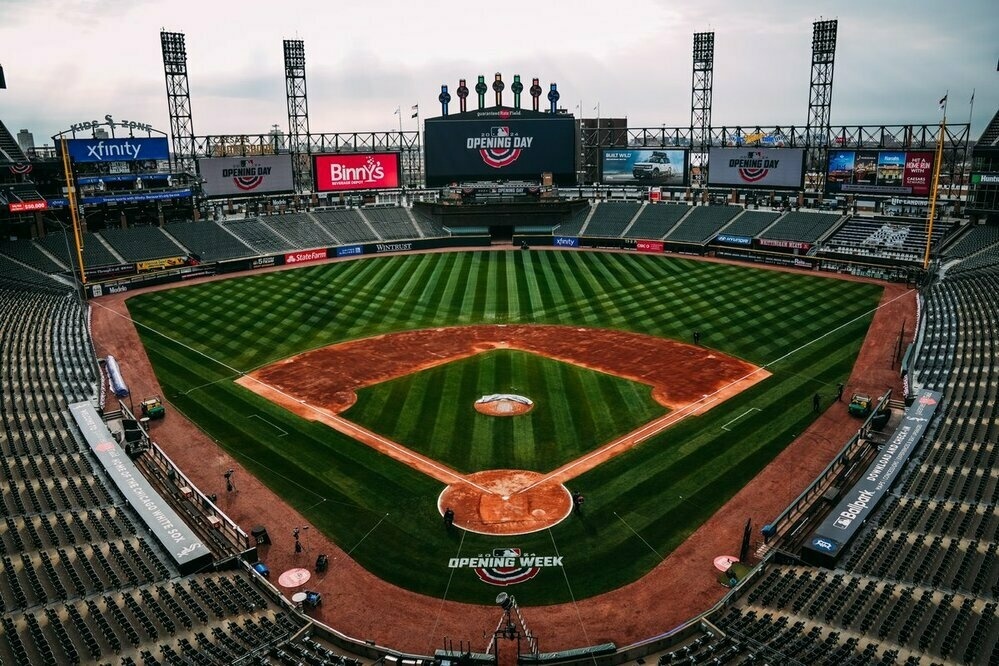 A wide shot of Guaranteed Rate Field. Opening Day imagery emblazons the video boards and is painted on the field behind home plate.