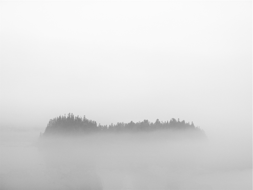 An island can be seen through a foggy cloud.
