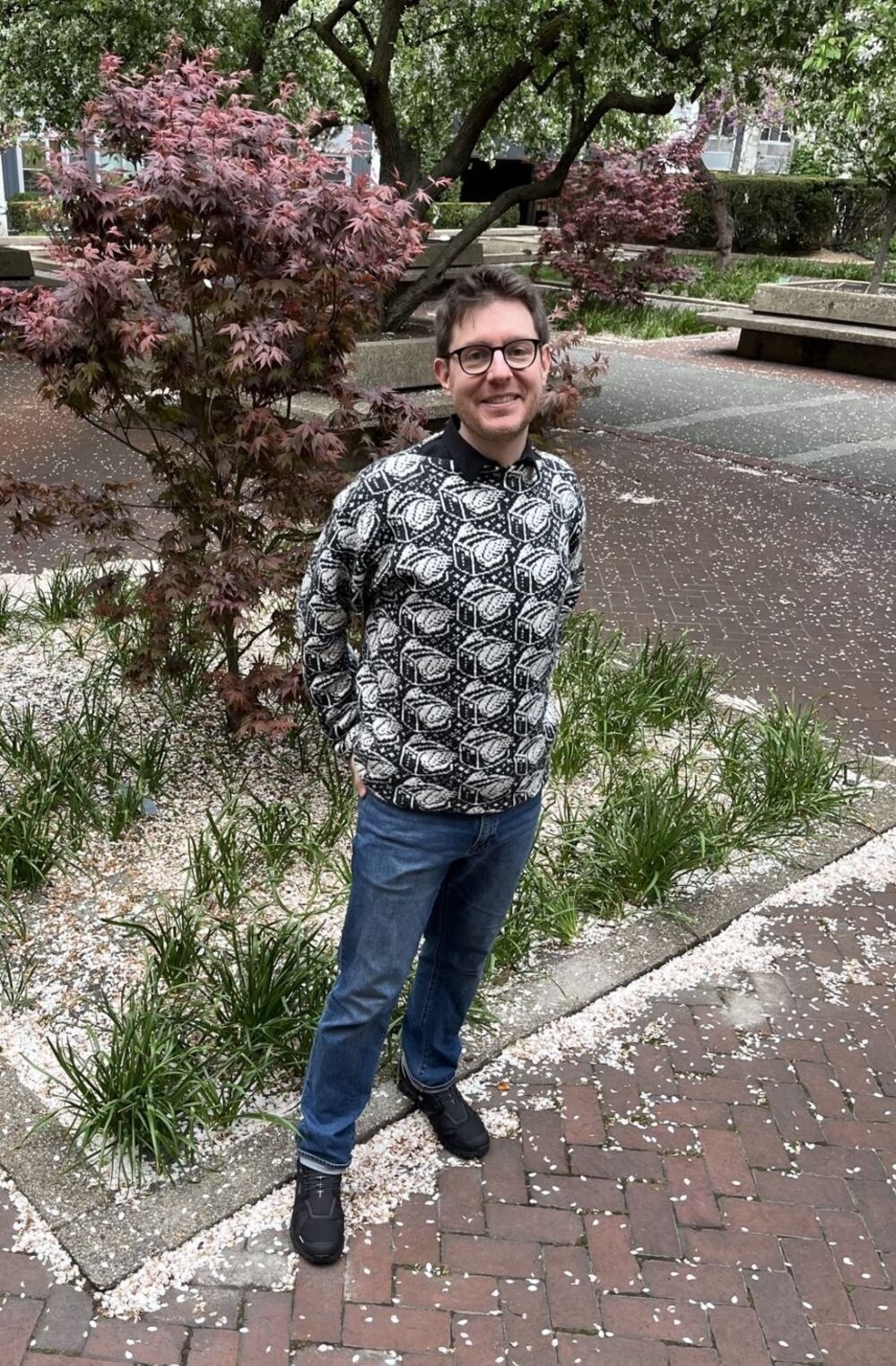 Me wearing a black and white sweater with a repeated Flying Toaster pattern inspired by the After Dark screensaver.
