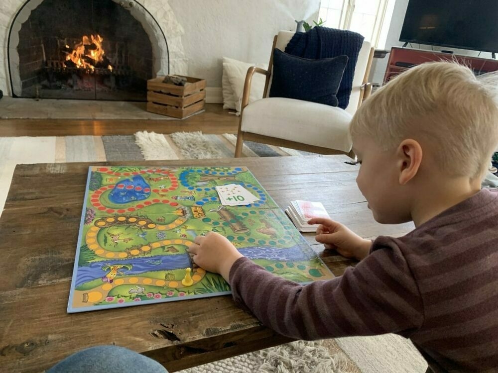 Photo of my son playing a board game with a fire burning in the background