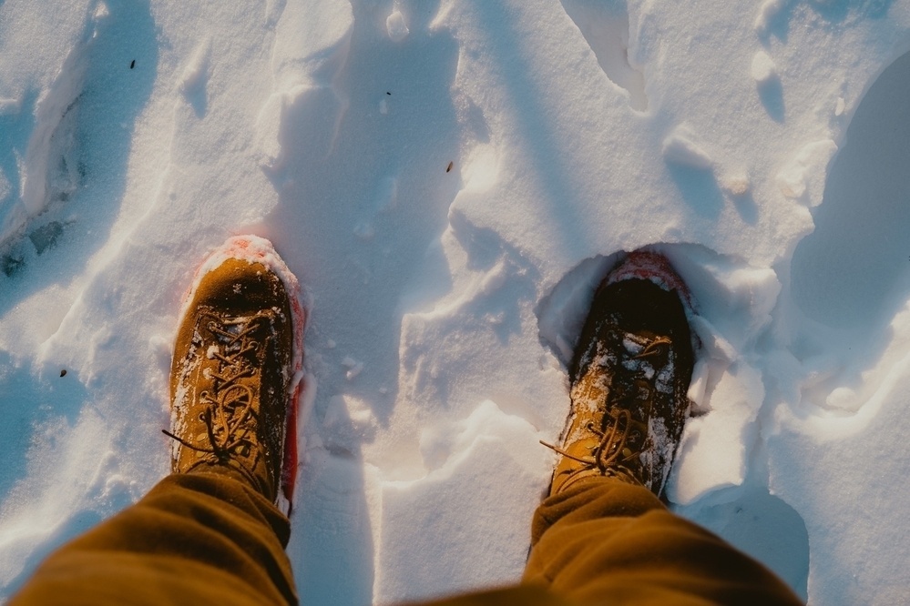 Looking down at my boots in the snow with the sharp light and shadows of the setting sun.