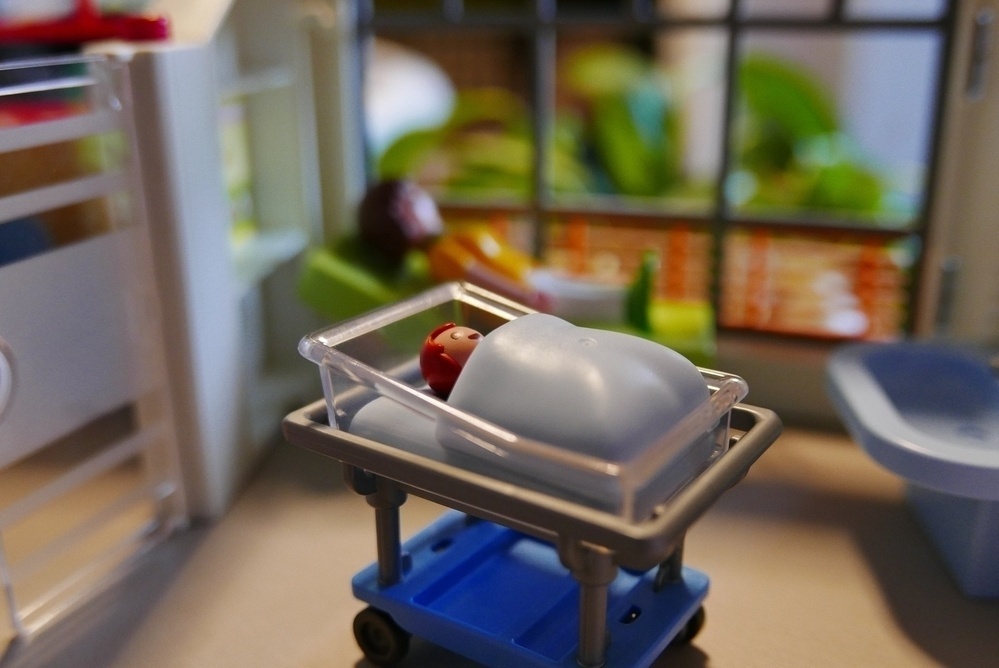 A photograph of a Play-Mobil baby in a delivery room