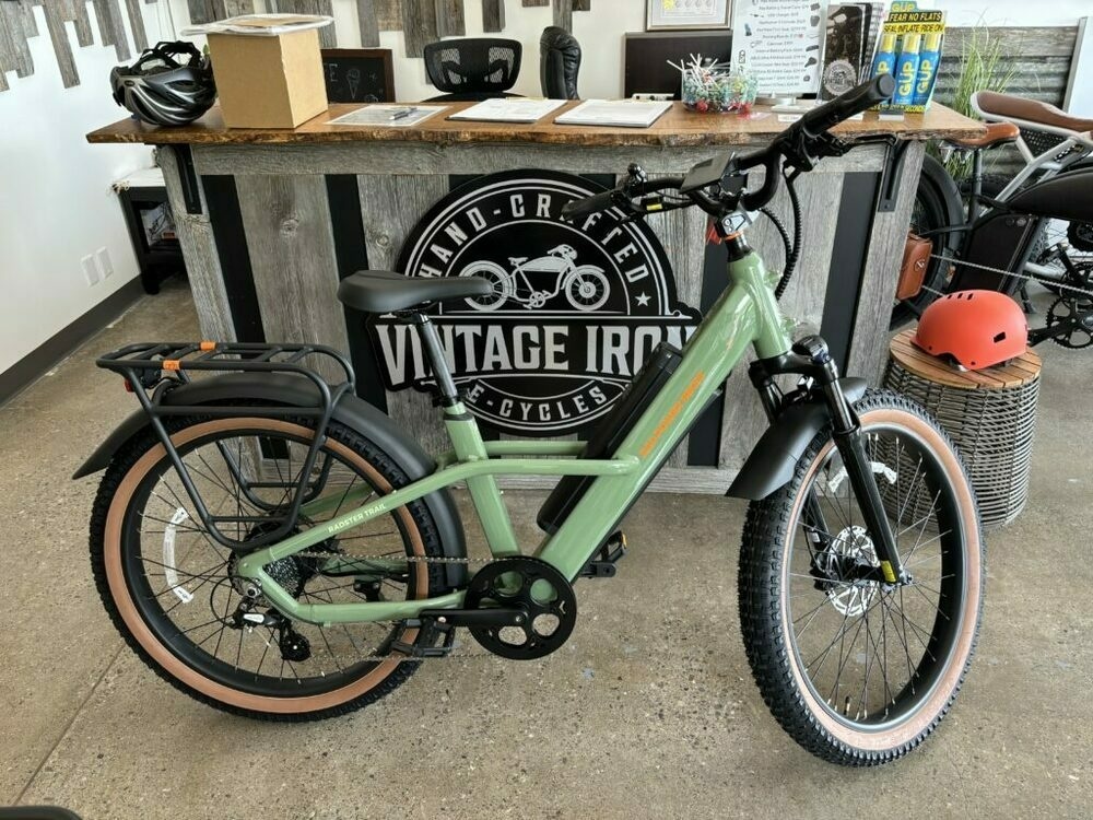 A brand new green Radster Trail e-bike in the Vintage Iron Cycle store in front of the checkout counter.