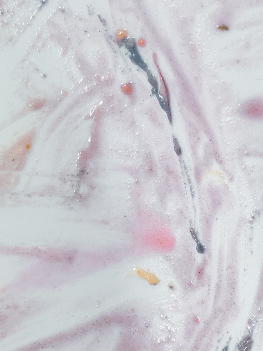 photo of slimy-looking and somewhat artless smears on a whitish surface in rather pretty shades of pale to bright pink, purplish to mauve, deep greenish greyish blue, and orange.