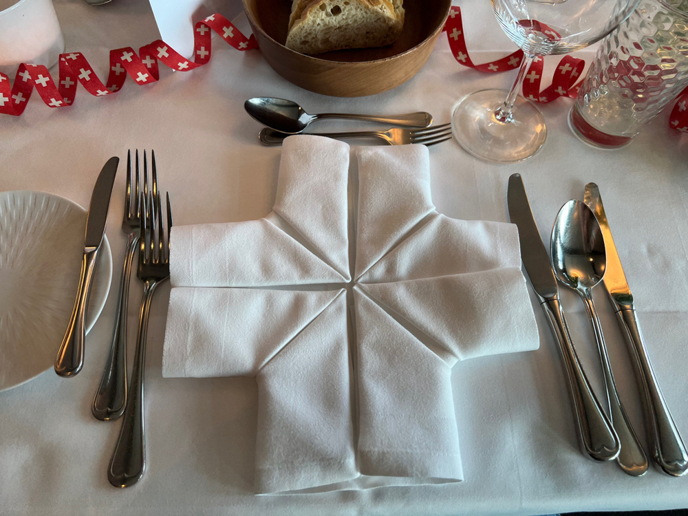 A napkin folded into a cross on festive table. 