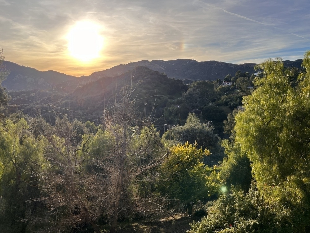 A sunset over lush mountains 