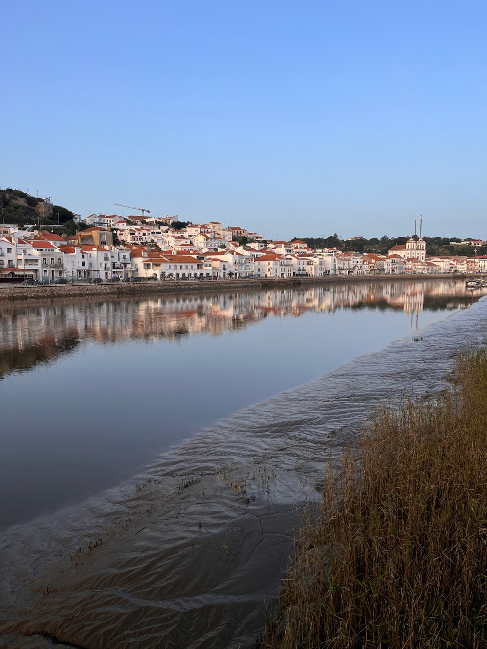 Alcácer do Sal, Portugal, from over the River Sado. The river is so still that the town is reflected in the river.