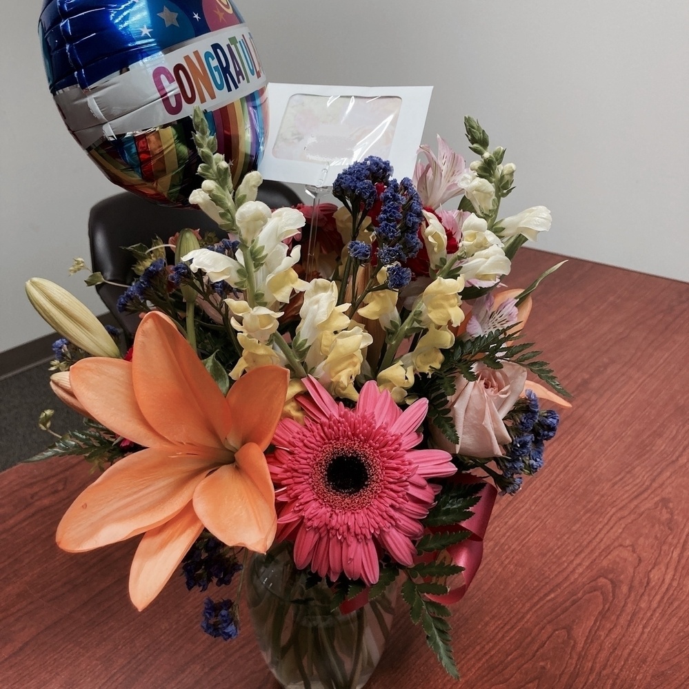 Flowers in a vase with a congratulatory balloon