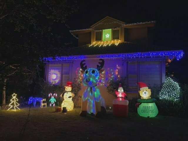 a house at nighttime, with an array of illuminated, inflated Christmassy creatures in the front yard
