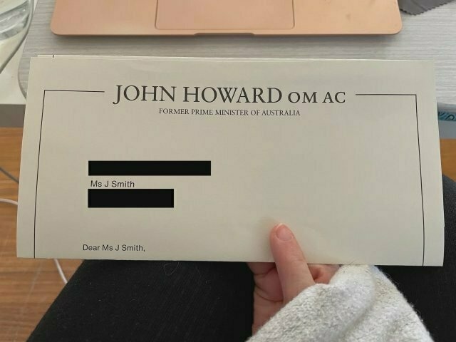 A letter with â€œJohn Howard OM AC, former Prime Minister of Australiaâ€� (except all-caps) at the top. The letter is addressed to â€œMs J Smithâ€� (I blacked out my address) and begins â€œDear Ms J Smith,â€�. I am holding the letter in my hand and it is folded so no more of the letter is visible than that.