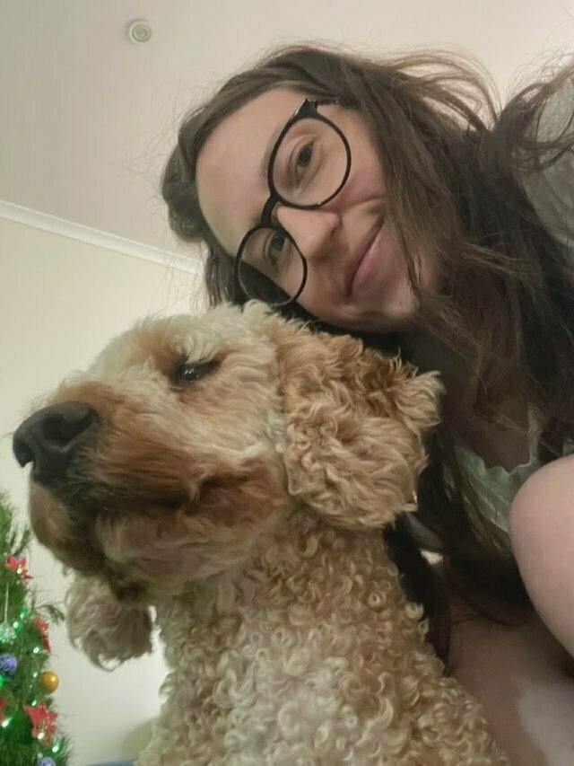 Another selfie at a similar angle, but this time the dog is looking away. There's also a Christmas tree now visible in the background.