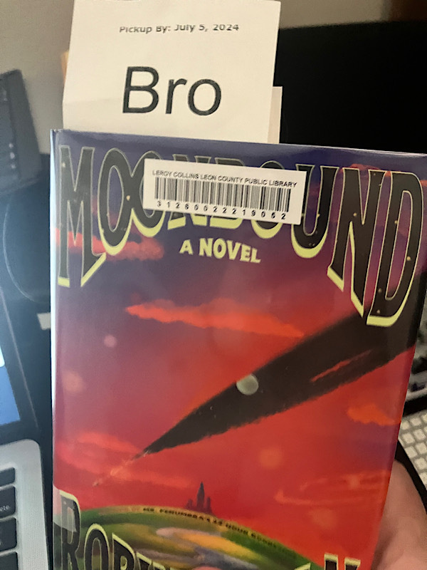 library-plastic-wrapped copy of Robin Sloan's new novel Moonbound, with a receipt sticking out the top that reads "Bro" (the first three of my last name - it's a system thing.)