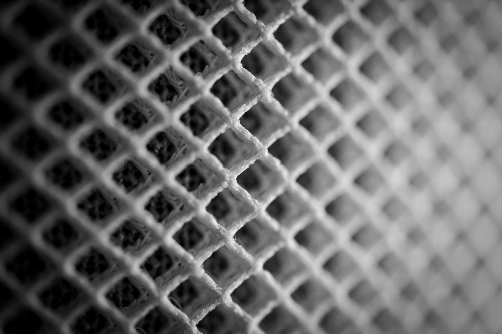Black and white close-up shot of the white mesh outside of the Apple HomePod.