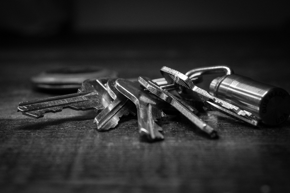 Black and white photo of a set of metal keys on a wooden table