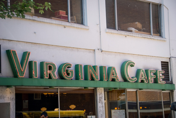 A building facade features a neon sign reading Virginia Cafe in green and red lettering.